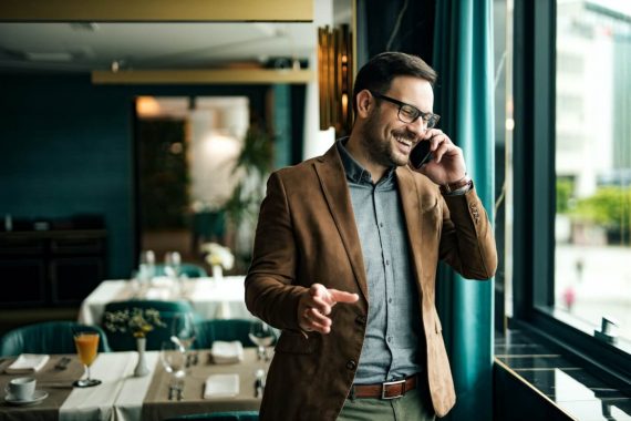 Portrait of a smiling businessman in restaurant talking on smart phone. Portrait of a smiling businessman in restaurant talking on smart phone.