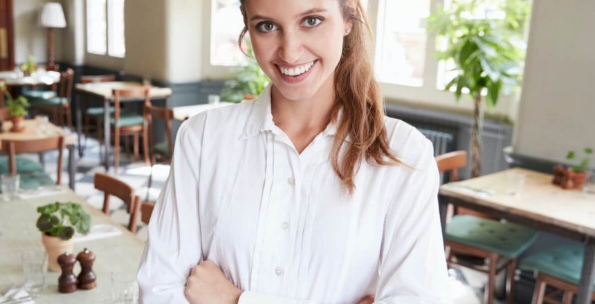 Portrait Of Female Restaurant Manager In Empty Dining Room