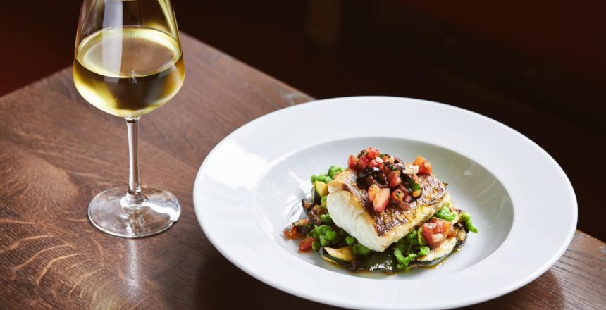 White wine and cod dish in restaurant