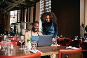 Restaurant managers working with laptop